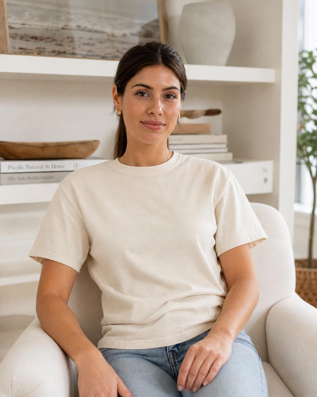 Blank t-shirt mockup — Cream armchair beside a bookshelf